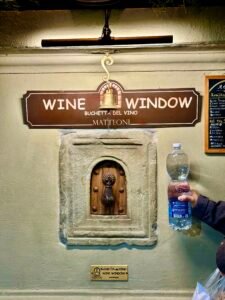 佛羅倫斯葡萄酒之窗 Buchetta del Vino,從牆壁遞出紅酒的特寫