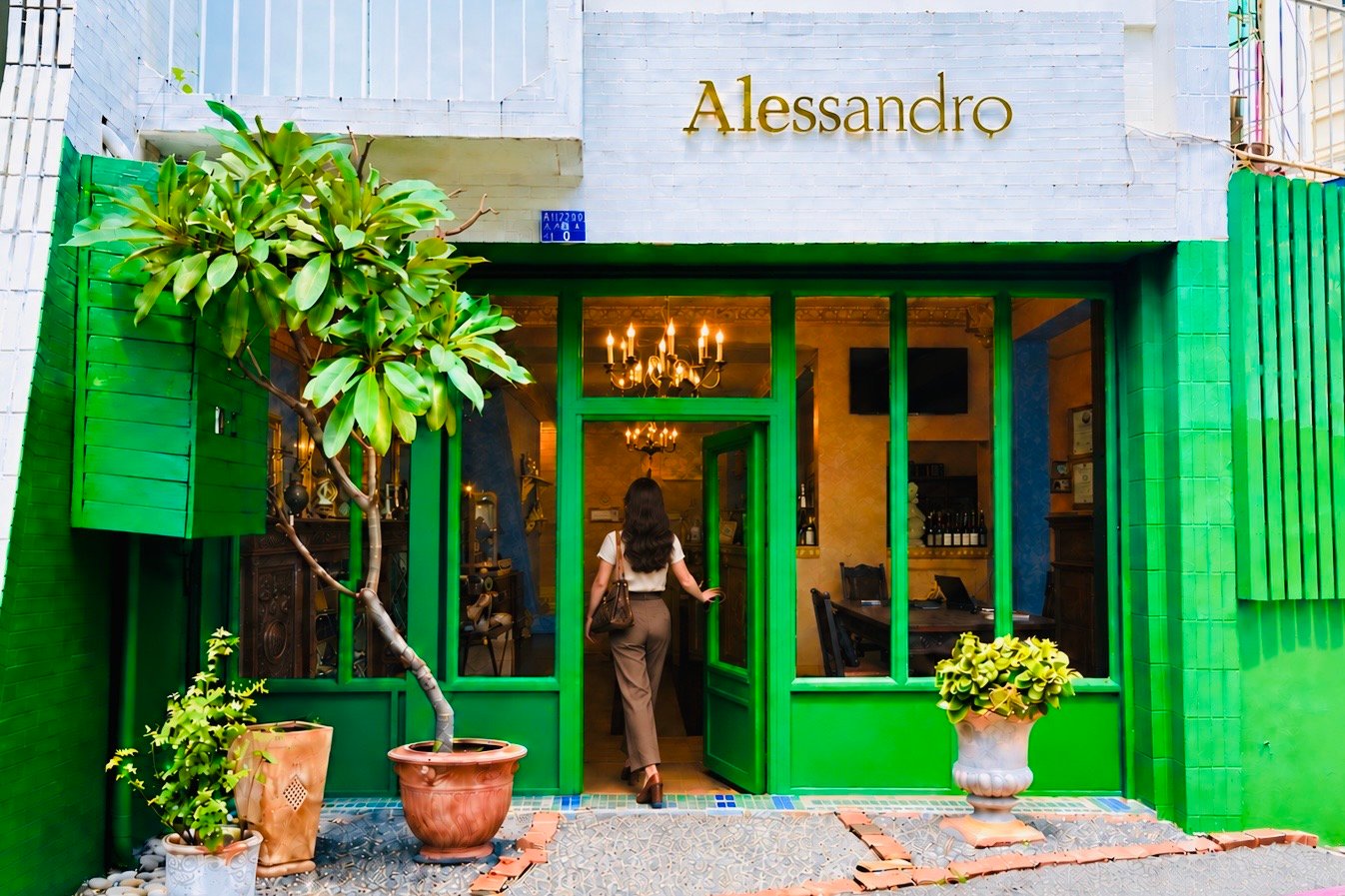 Alessandro 入口形象:女士側身開門走入,玻璃後可見歐式室內空間