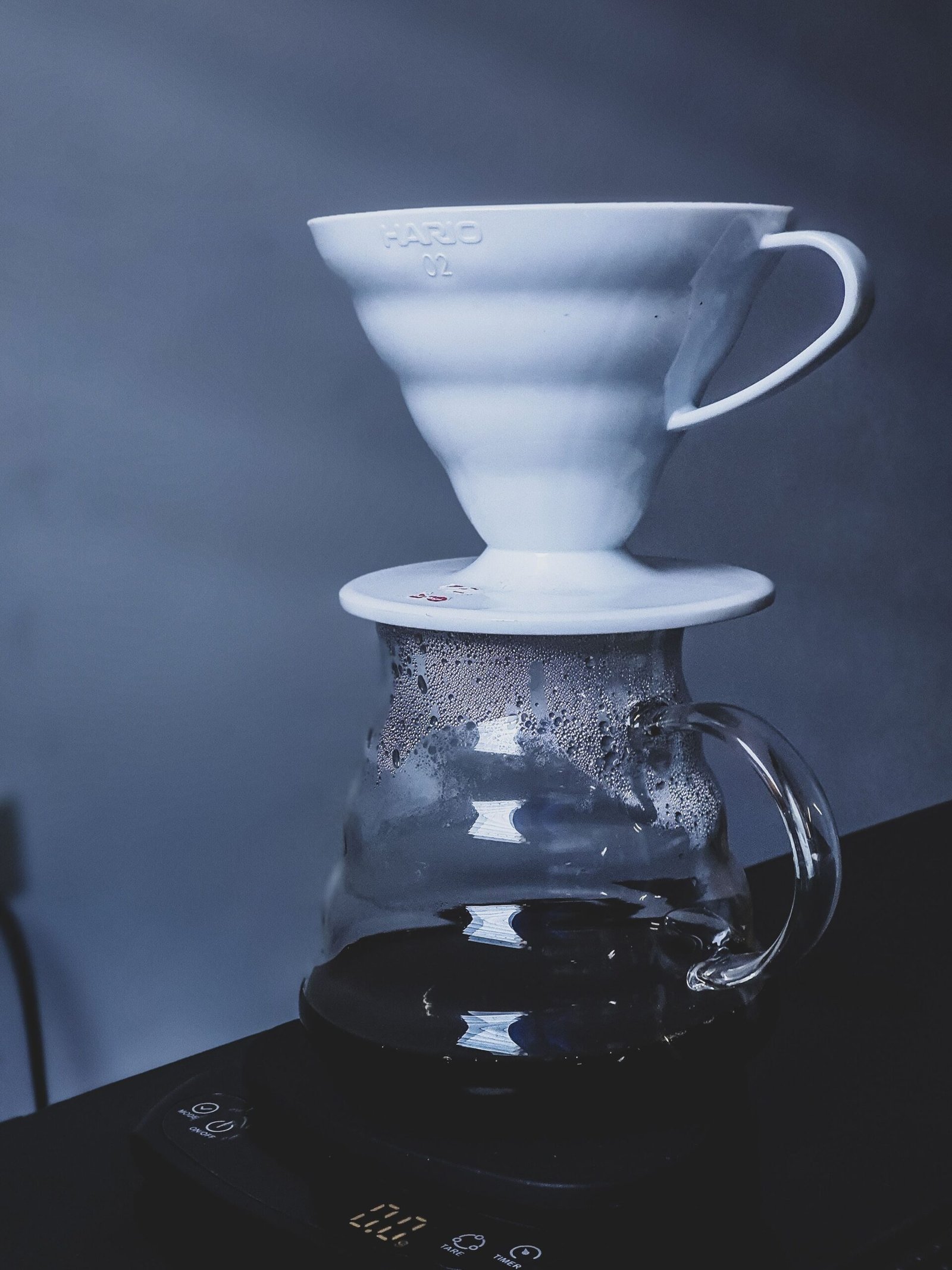 一般白色錐形濾杯、玻璃分享壺與電子秤，示意沖煮前固定器材與重量