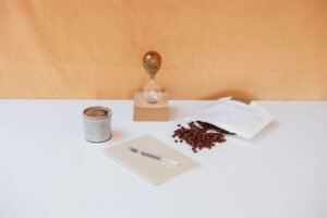 沙漏、咖啡豆、筆記本與一杯咖啡放在桌上,呈現年度學習與時間規劃